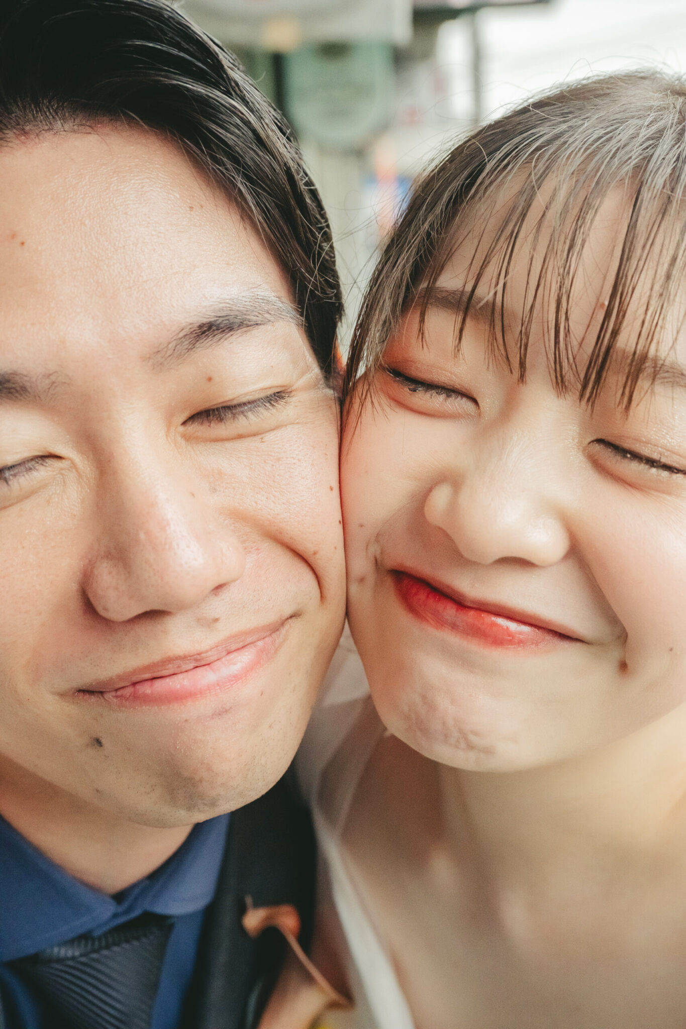 お互いの顔をくっつけて幸せそうなクシャクシャの笑顔を見せる新郎新婦のウェディングフォト