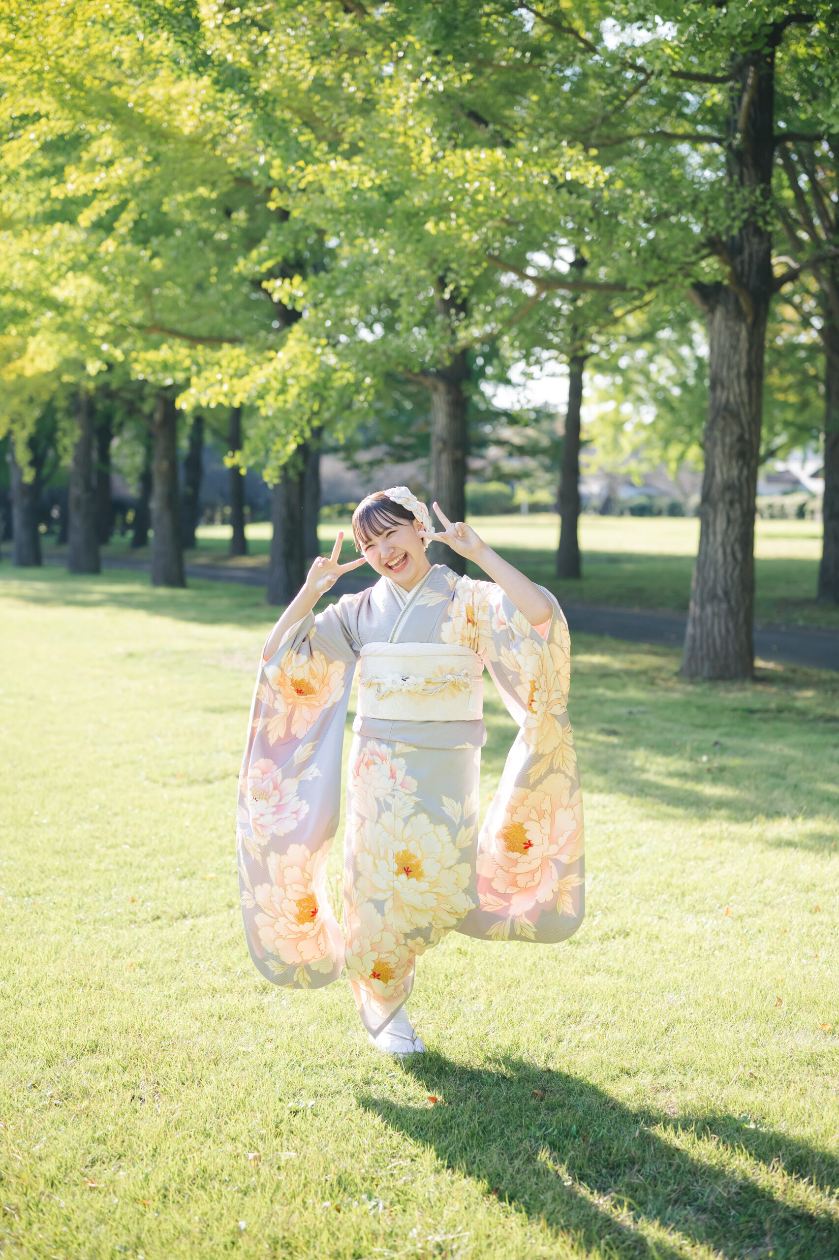 水戸の広大な芝生エリアでウキウキした足取りで全身でハタチを表現する自然体な成人式ロケーションフォト