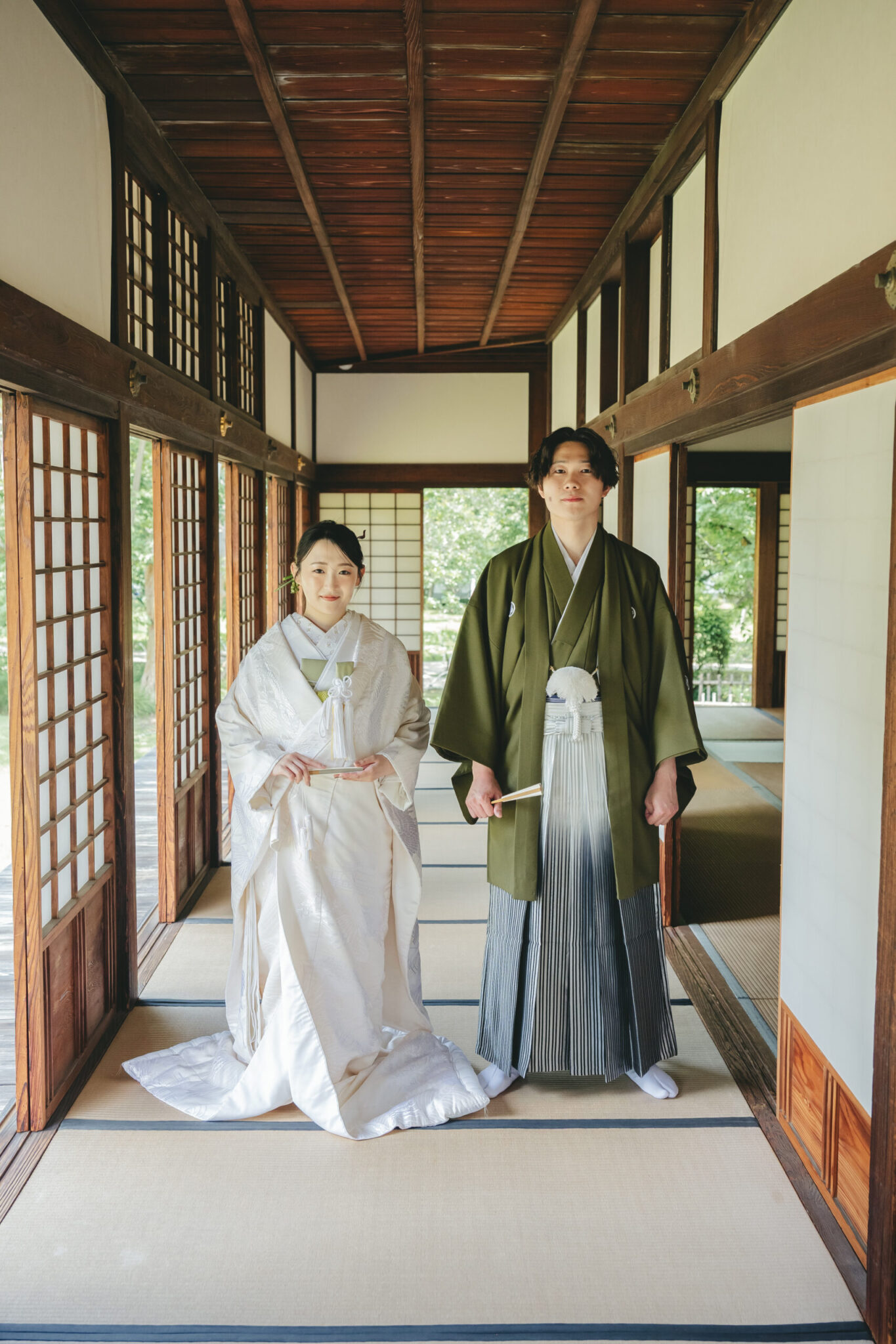 水戸市の弘道館で歴史を感じる長い木造廊下に佇む白無垢姿の新婦と紋付袴姿の新郎