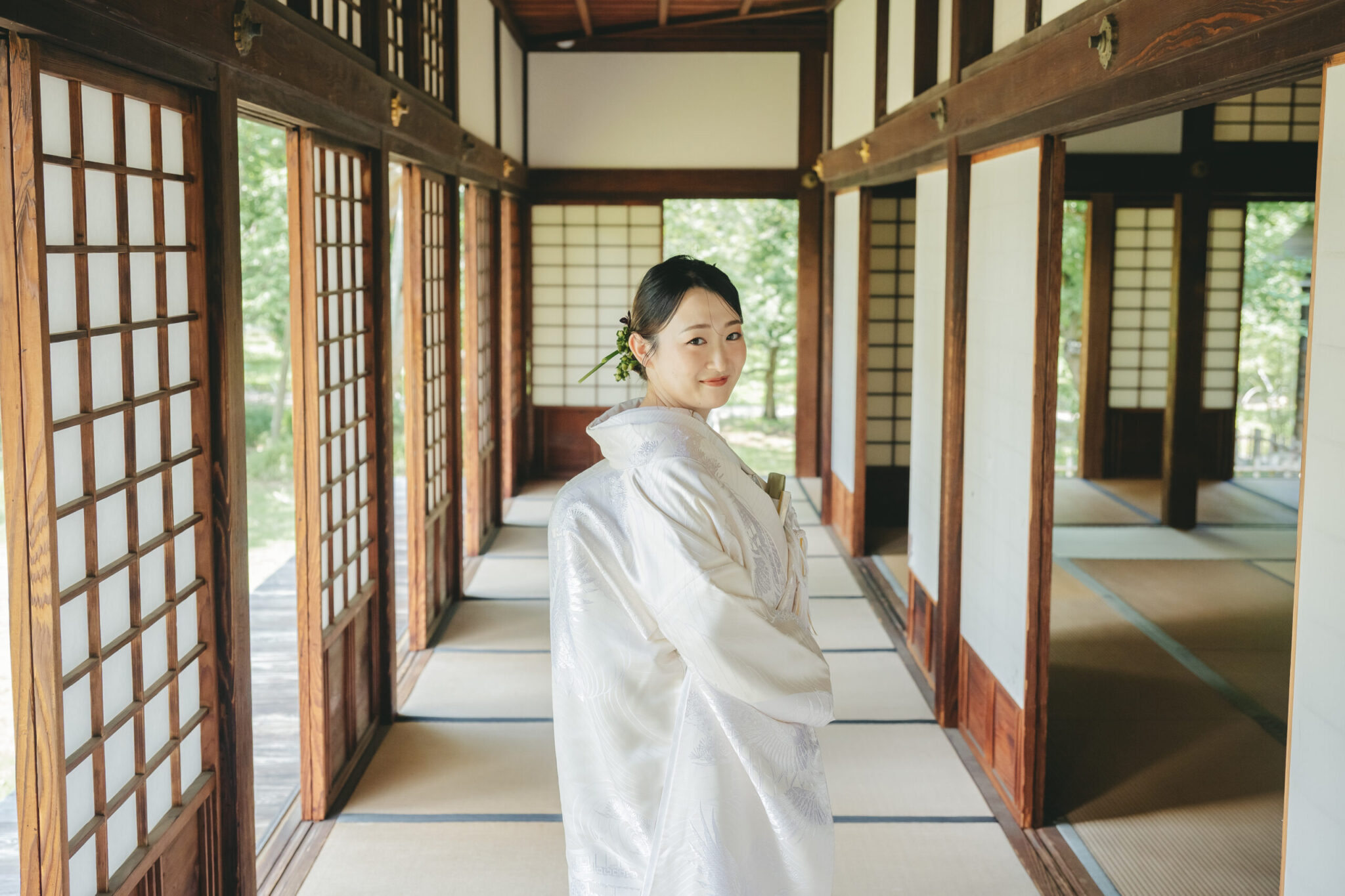 重要文化財・弘道館の趣ある廊下に差し込む自然光に包まれた白無垢姿の新婦ソロカット