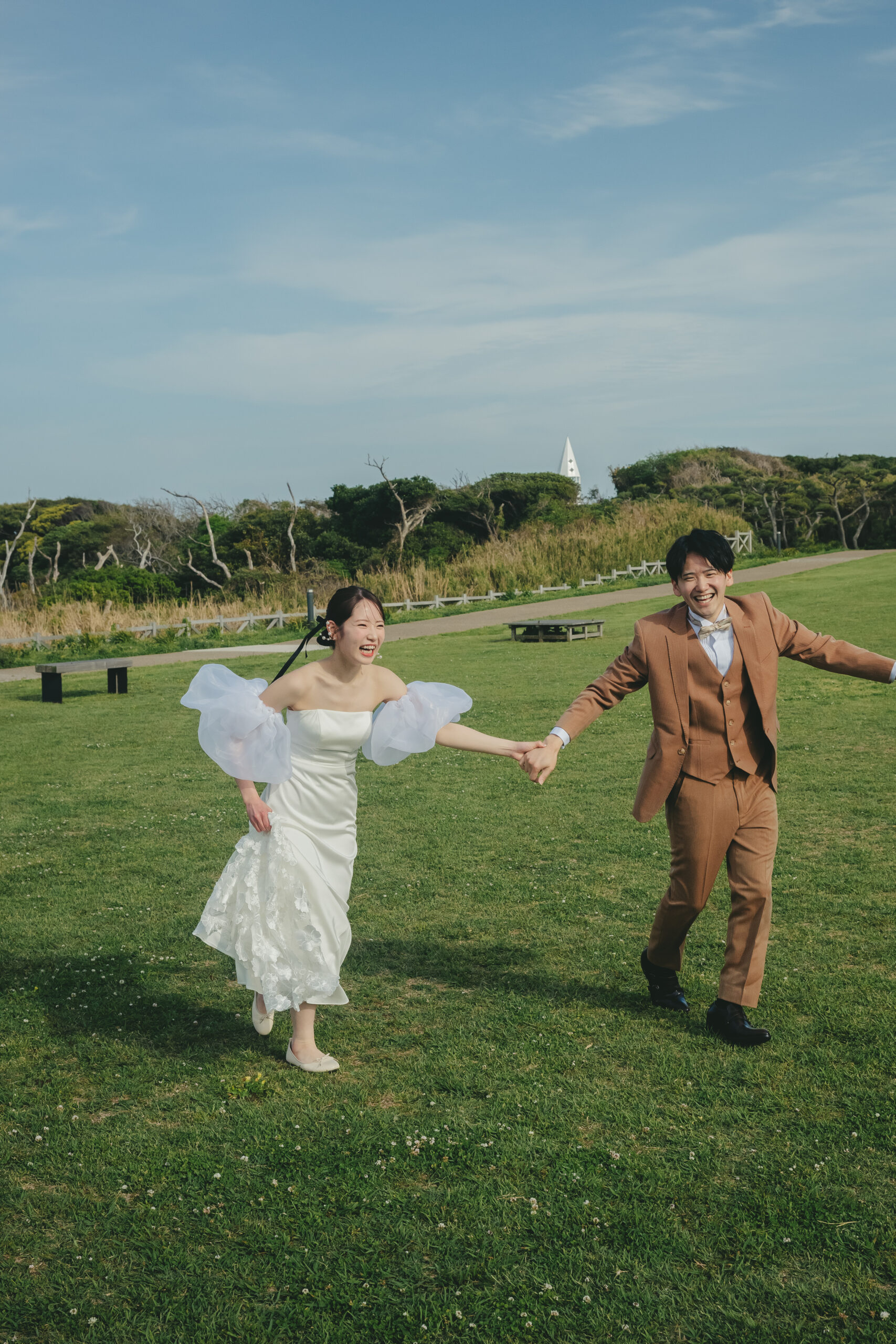 城ヶ島公園の芝生で二人で楽しそうに走る前撮りカップル