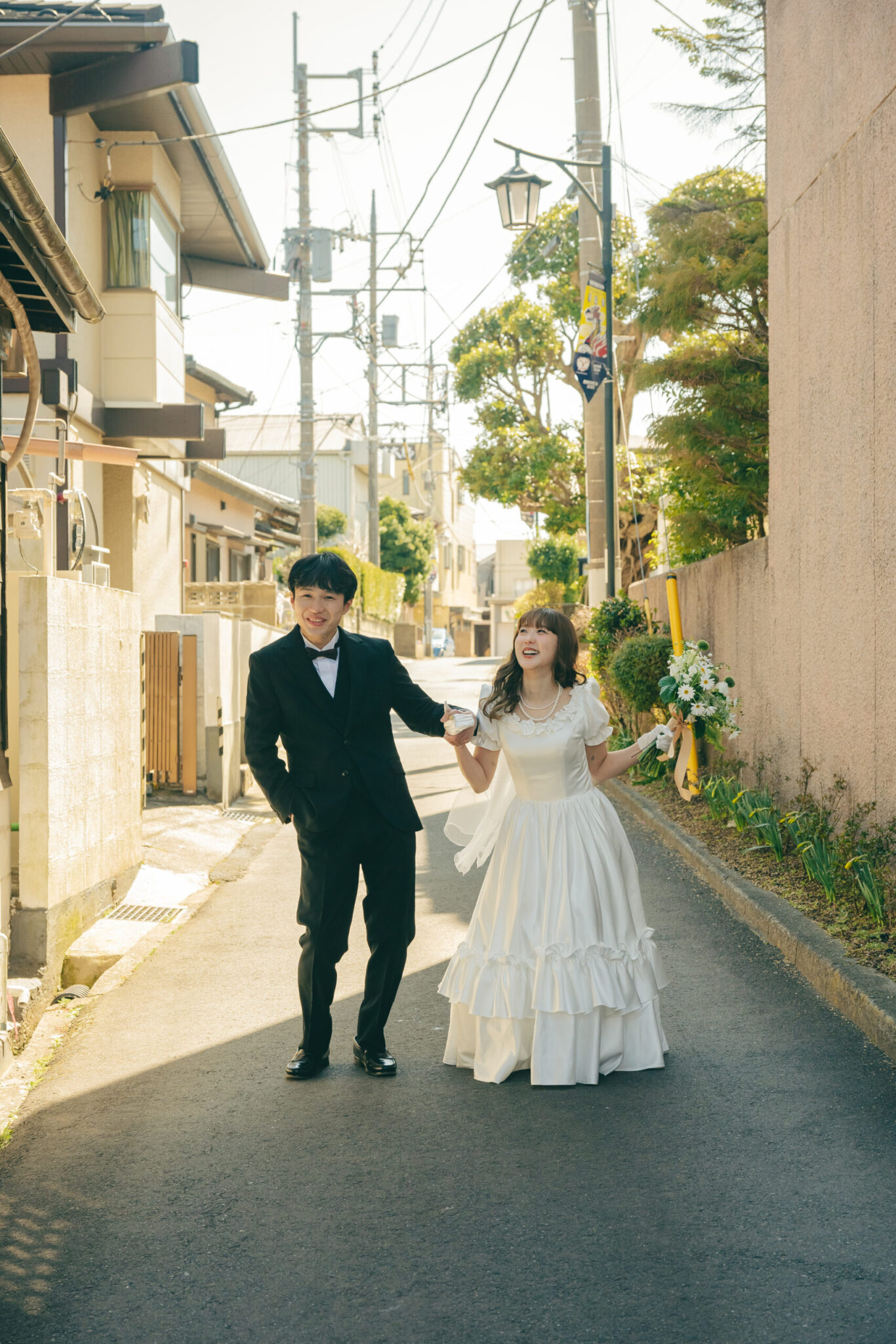ノスタルジックな雰囲気の古い路地裏ストリートでお互いを見つめ合って笑うエモいロケーション前撮り