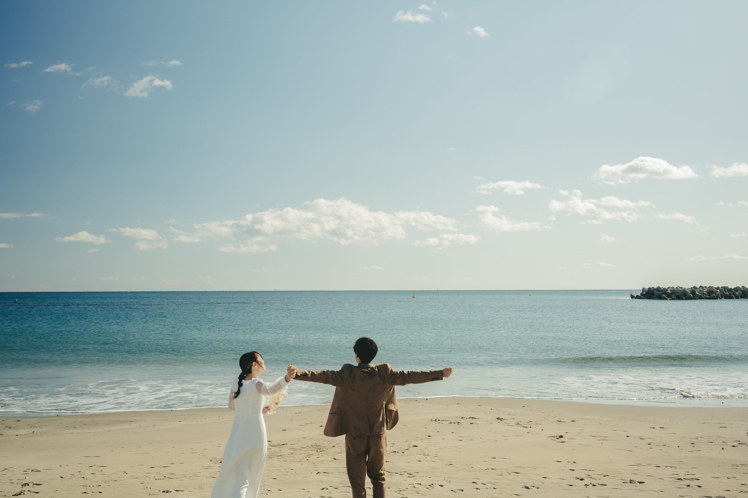 宮城県七ヶ浜町の菖蒲田浜海水浴場で手をつなぐ結婚式前撮りの影絵カット