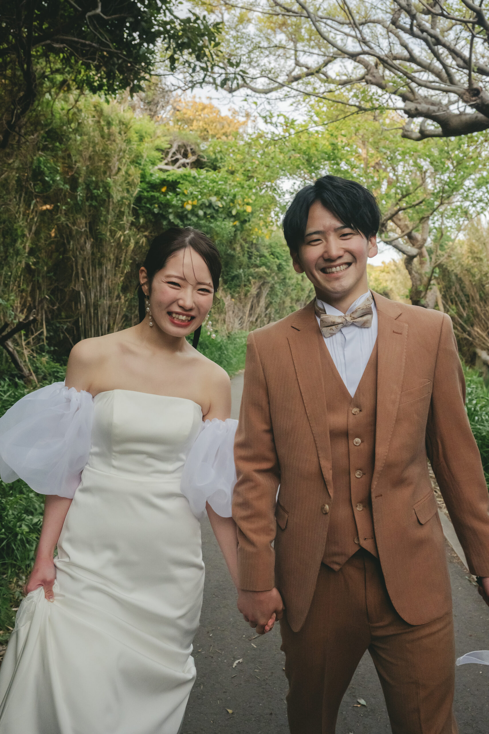 城ヶ島の緑のトンネルを仲良く歩く前撮りドレス姿の二人