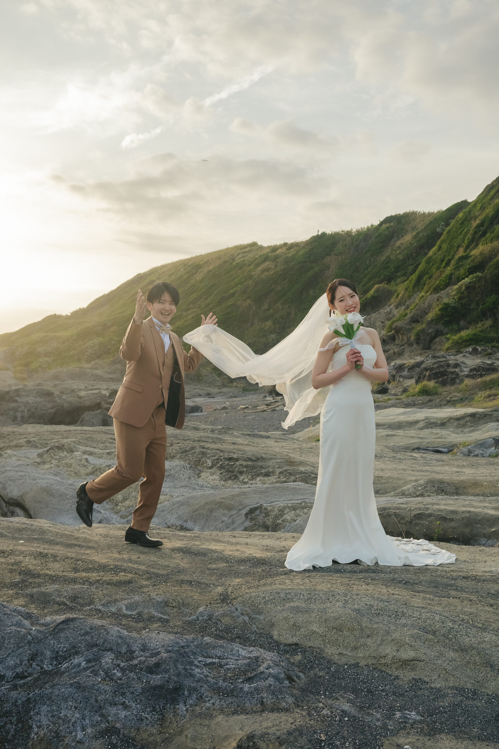 城ヶ島の夕刻の海と岩場を背景にロマンチックな前撮りポーズ