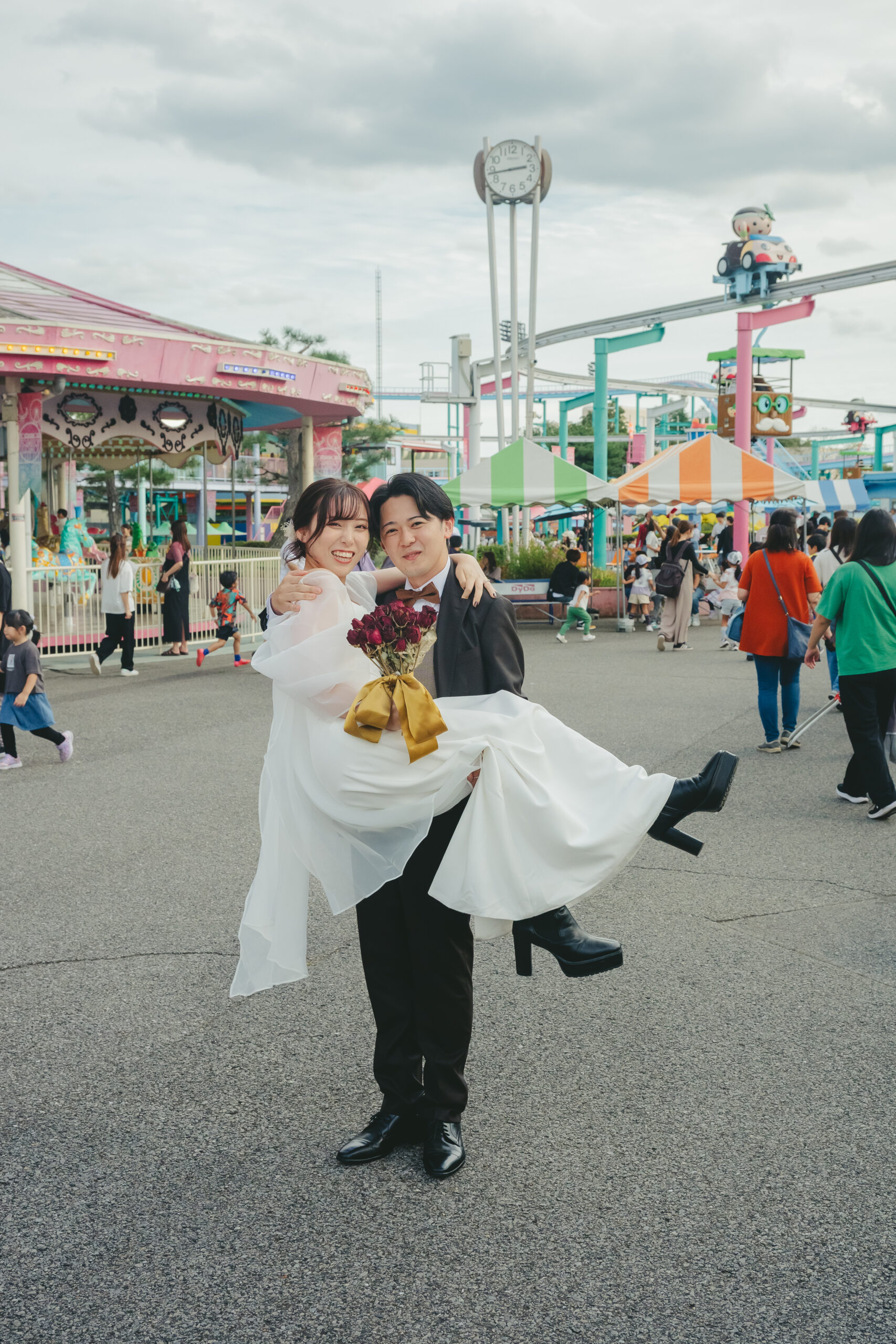 とちのきファミリーランドのメリーゴーランド前でドレス姿の新婦をお姫様抱っこする栃木の結婚式前撮り