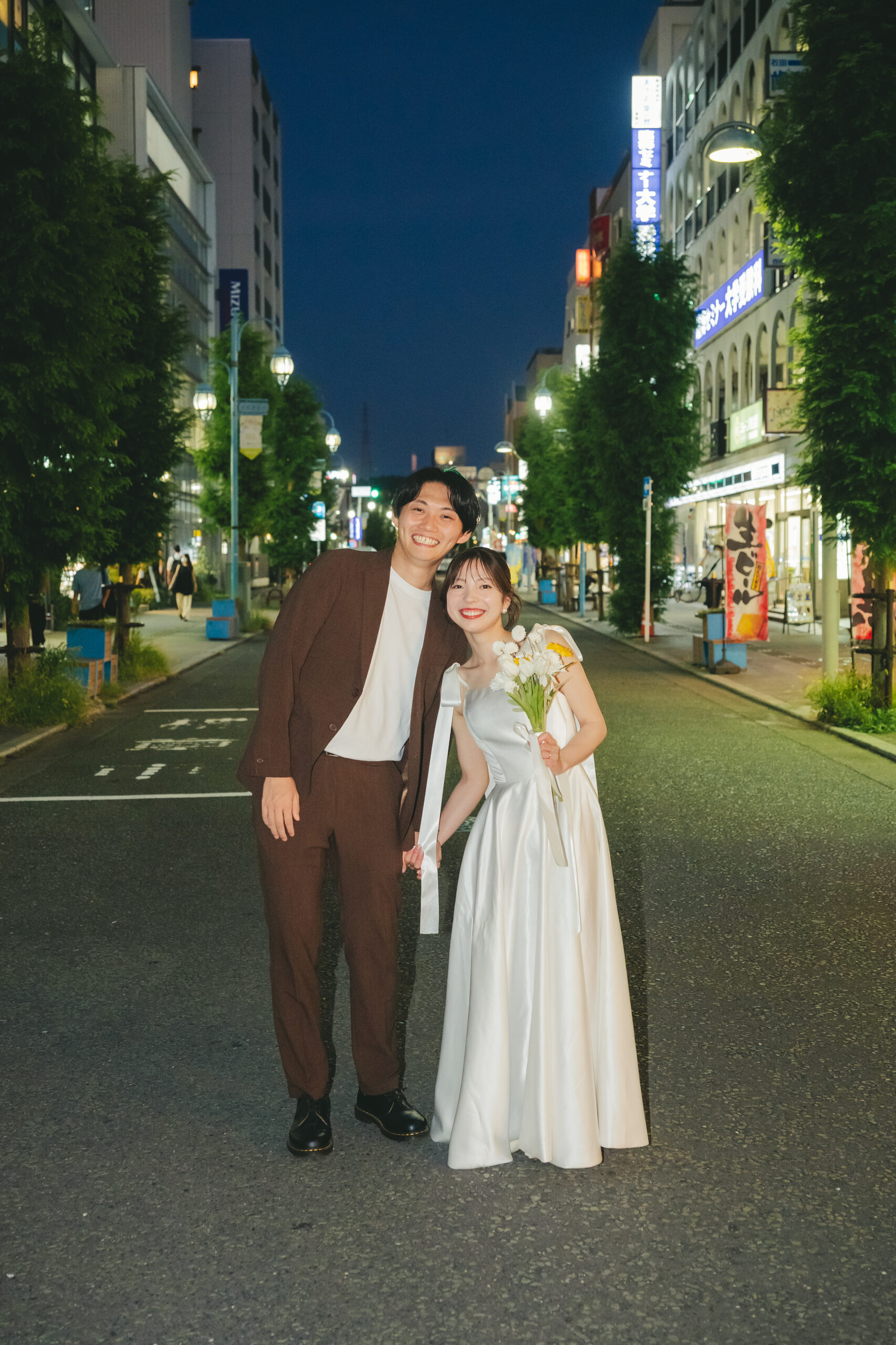 夜の街をドレス姿で手を繋いでスタイリッシュなナイト前撮り
