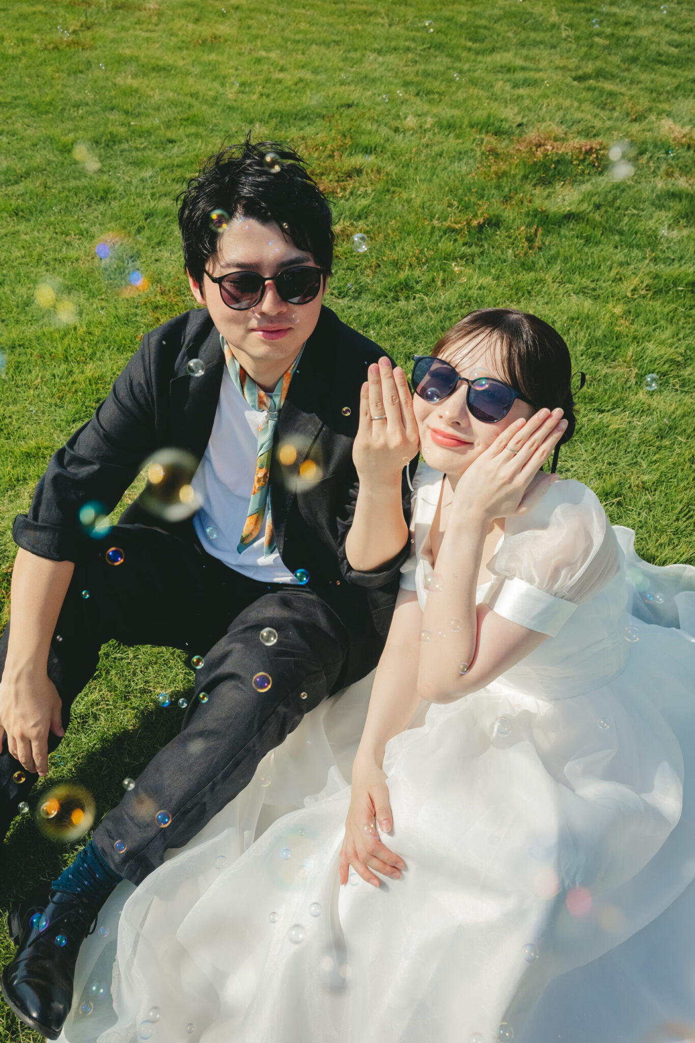 鹿島灘海浜公園の青々とした芝生の上でサングラスをかけてポーズを決めるおしゃれな結婚式前撮り