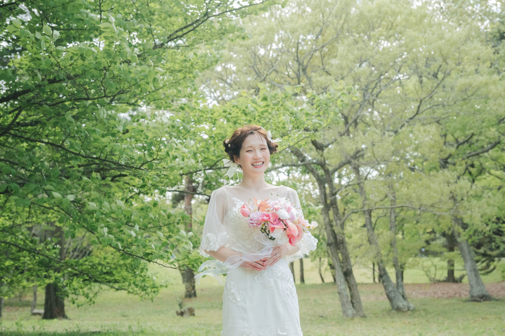 ひたちなか海浜公園の森に差し込む優しい木漏れ日に包まれたドレス姿の新婦美しいソロカット