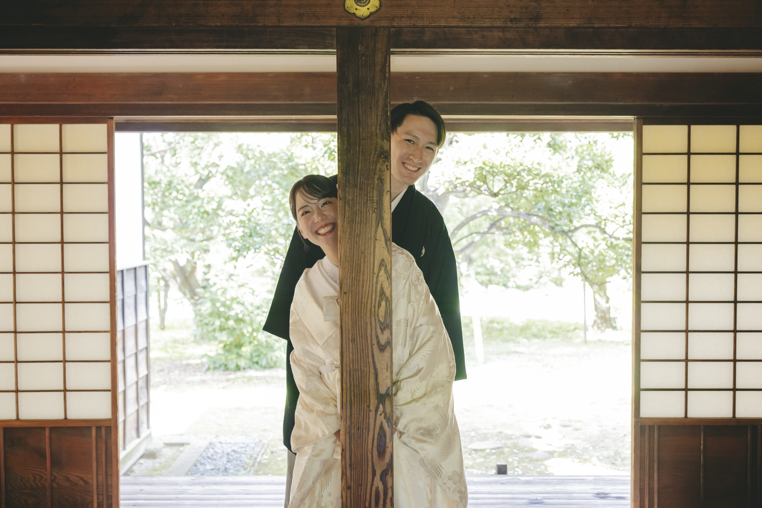 歴史ある弘道館の柱の陰から新郎新婦が笑顔で顔を覗かせる自然体で可愛い和装前撮り