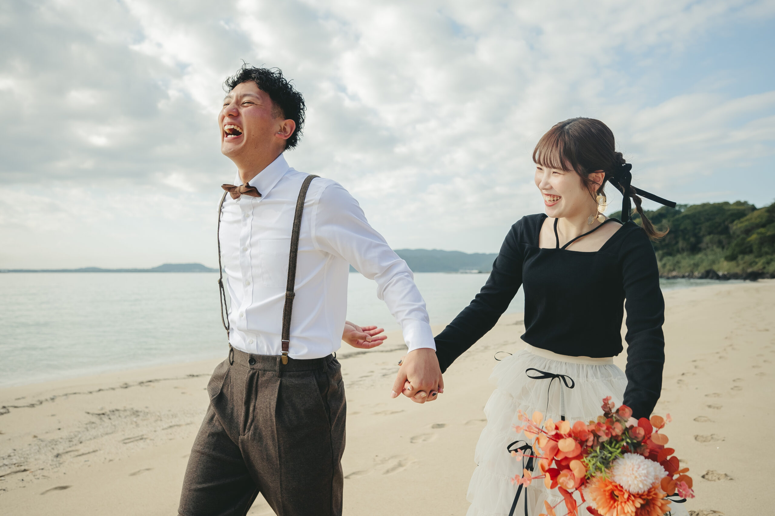 香珠子海水浴場の白い砂浜で前撮りする新郎新婦