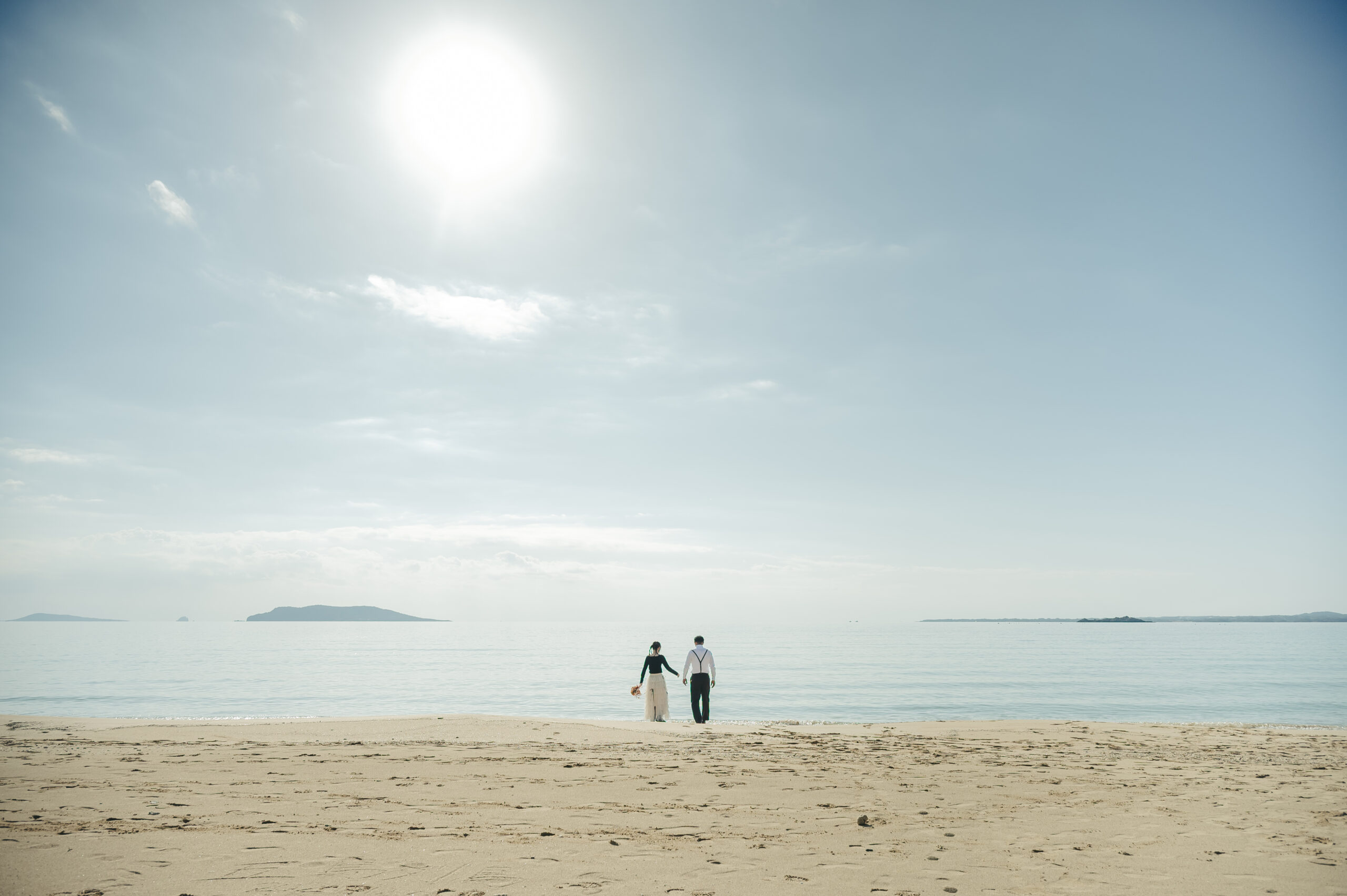 香珠子海水浴場の白い砂浜で前撮りする新郎新婦