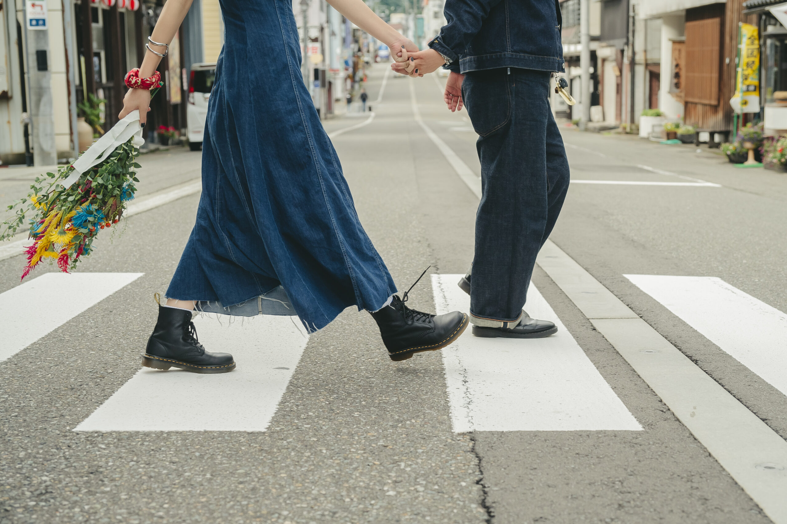 新潟県越後湯沢の温泉街の横断歩道をデニムコーデで手をつないで渡る前撮りカップル