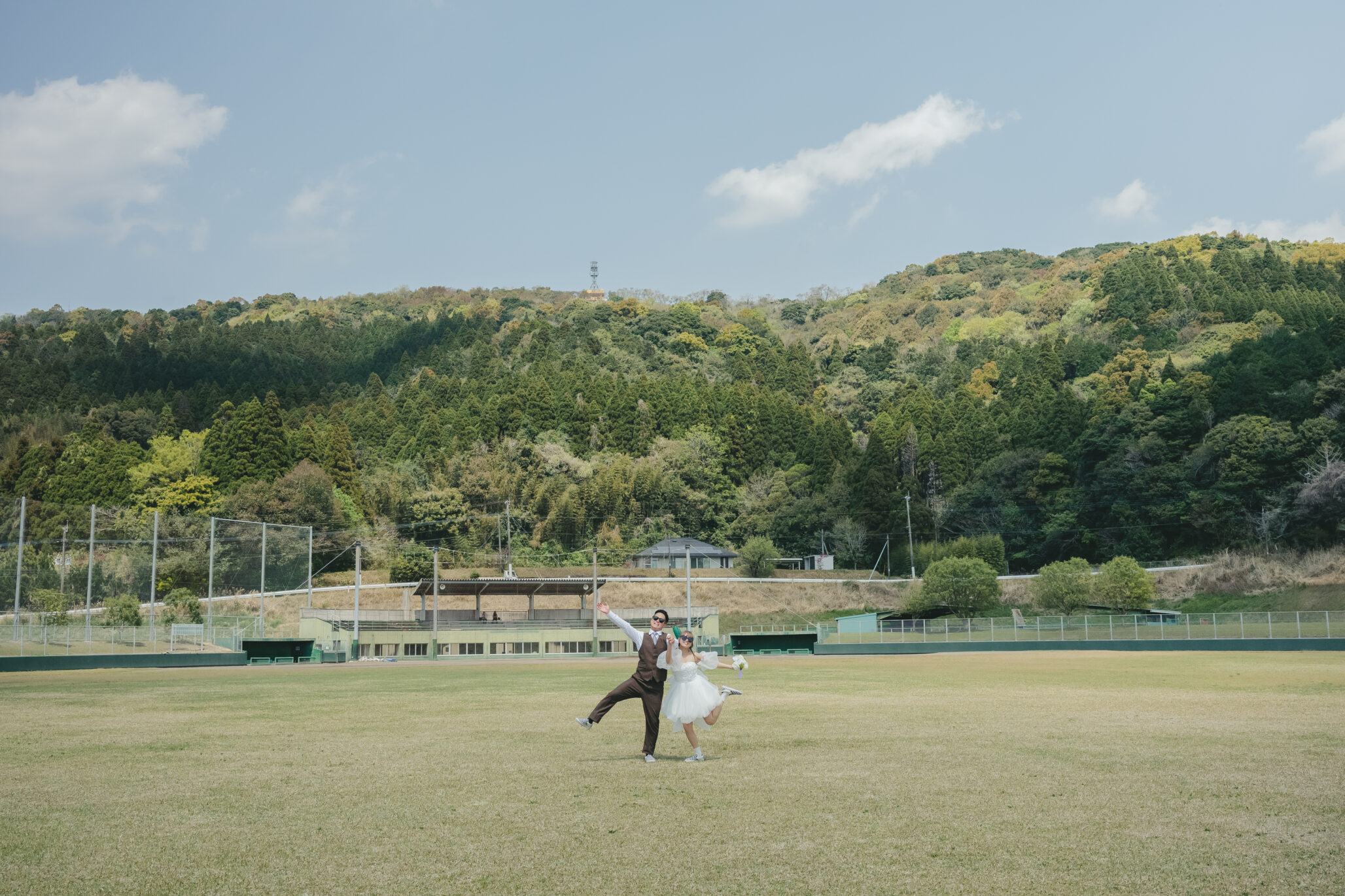 鹿児島県志布志市の有明球場で前撮りをする二人