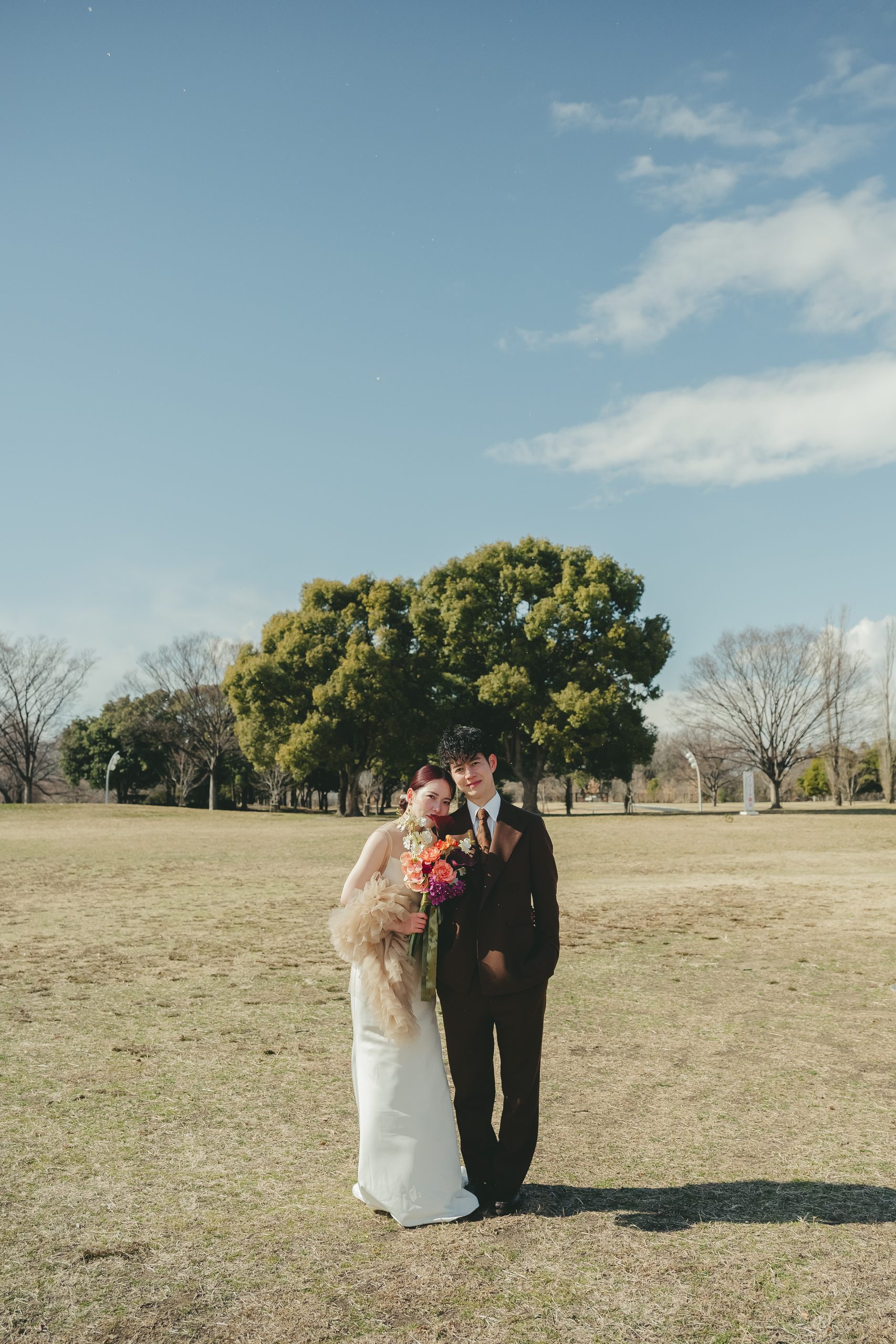 大阪での結婚式前撮りで広大なロケーションの中で開放的なウェディングフォトを撮影するカップル