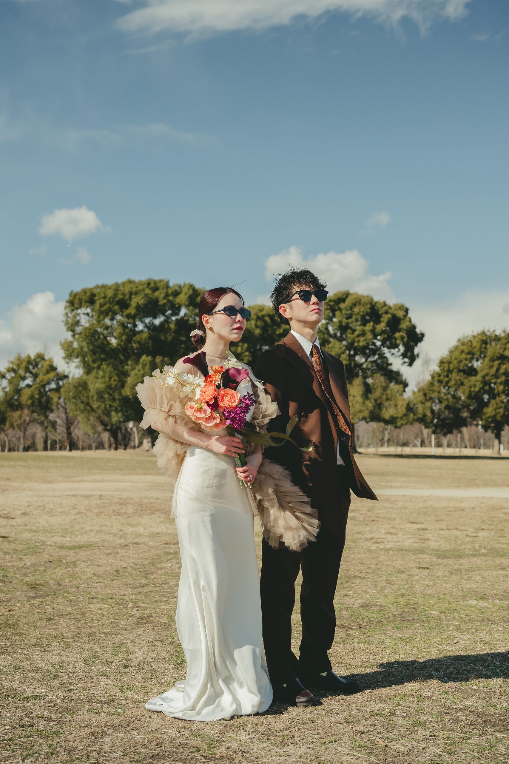大阪での結婚式前撮りで広大なロケーションの中で開放的なウェディングフォトを撮影するカップル